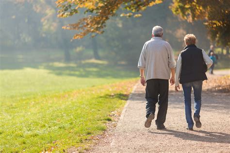 Senior Citizen Couple Taking A Walk In A Park During Autumn Morning