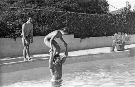 Two Men Are Playing In The Pool With Each Other While One Man Balances