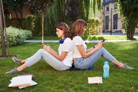 Girls Sitting Back To Back At The Grass Stock Image Image Of Portrait