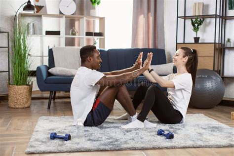 Loving Caucasian Woman With Her African Husband Doing Abs Exercises And Giving Each Other High