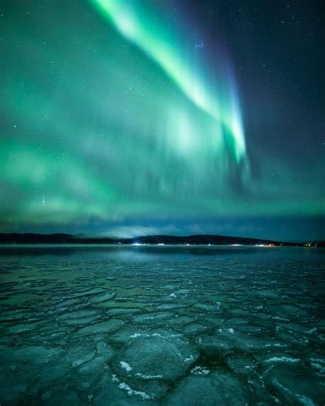 The Northern Lights Hover Over A Frozen Lake In Alaska Photorator