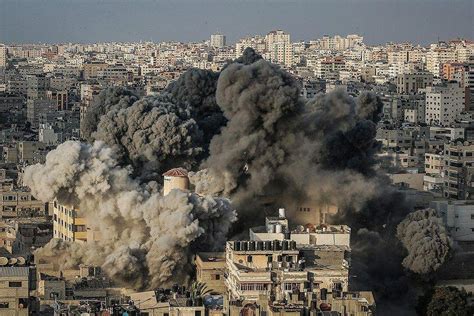 Rockets fired from gaza city are seen streaming towards israel this morning as the two sides pictured: IDF destroys multi-story building in Gaza City