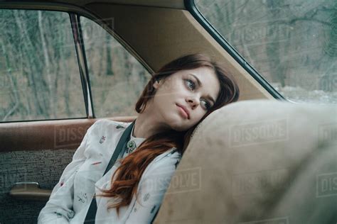 Woman In Back Seat Of Car Looking Out Window Stock Photo Dissolve