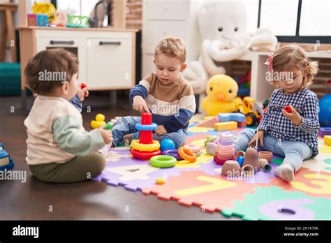 Group Of Kids Playing With Hoops Toys Sitting On Floor At Kindergarten