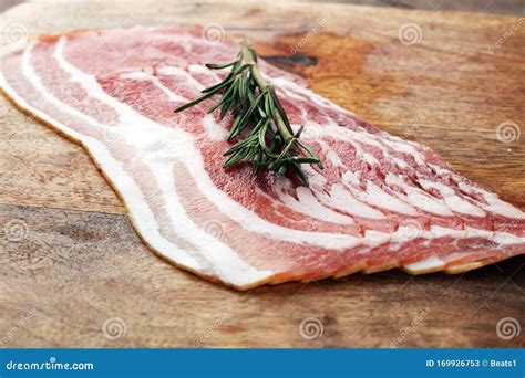 Fresh Cold Sliced Bacon With Rosemary On The Wood Background Delicious