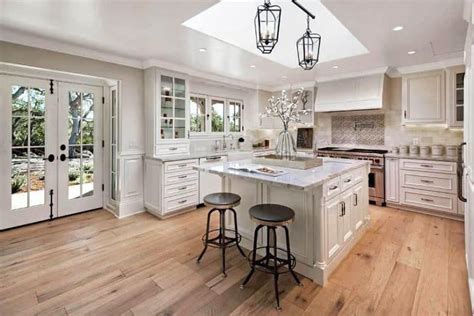 The actual extra amount of hardwood used under the cabinet area is minimal, and will make installation easier and faster than working around the cabinet. light hickory hardwood floor with swivel bar stools under ...