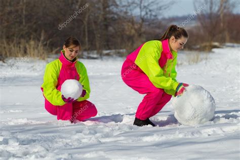 Girls Rolling Huge Snowball Stock Photo By ©korolok 102074182