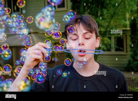 Teenage Boy Blowing Soap Bubbles Stock Photo Alamy