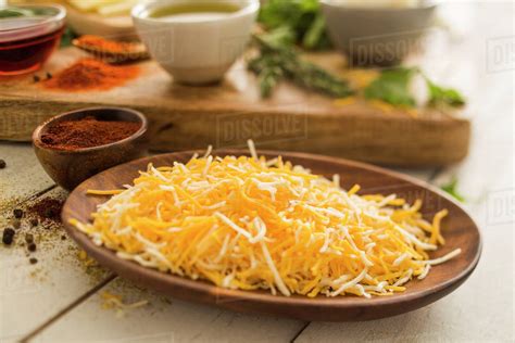 Shredded cheese on wooden plate - Stock Photo - Dissolve