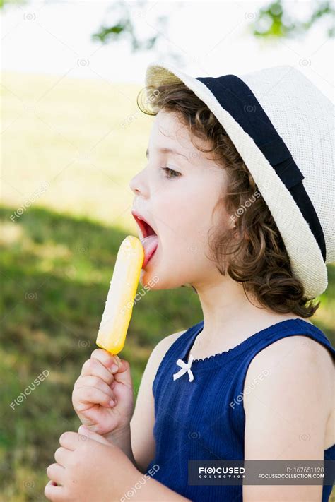 Girl Eating Popsicle Outdoors Sun Hat Summer Stock Photo