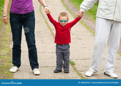 Little Boy Holding Hands Of His Parents Stock Photo Image Of Glasses