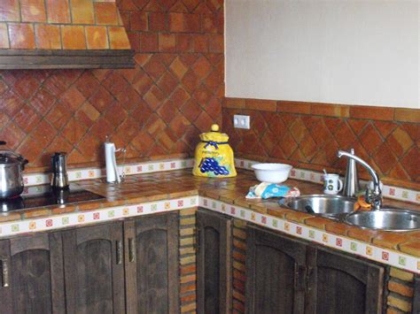 Estantes abiertos, azulejo tipo metro en el antepecho en color blanco, y muy parecida, pero con un toque rústico encantador en la zona del comedor con la pared de ladrillos vistos y la gran lámpara de forja en forma de candelabro. Suelos de barro: diciembre 2012