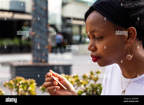 Close Up Side Profile Of Pensive African Woman Staring At Pen Or Spoon