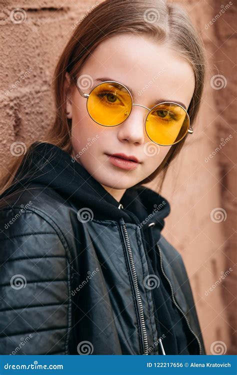 Beautiful Fashionable Kid Girl In Yellow Sunglasses In City Street