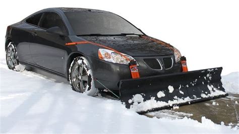 A Car Is Parked In The Snow With A Snow Plow Attached To Its Front