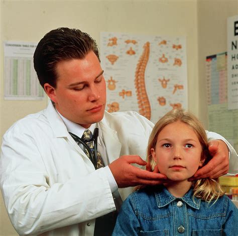 Gp Doctor Examines Young Girl For Swollen Glands Photograph By Saturn