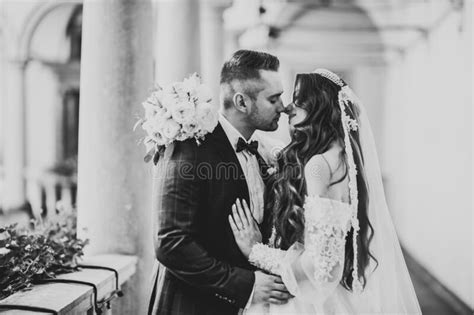 Beautiful Bride And Groom Embracing And Kissing On Their Wedding Day