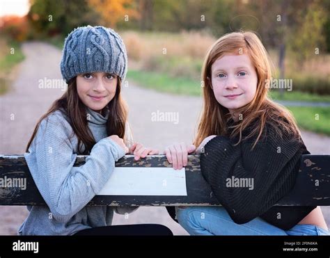 Two Young Tween Girls In Sweaters Outdoors On Country Road Stock Photo