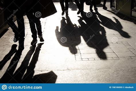 Blurry Shadow Silhouette Of People Walking On Pedestrian Street In
