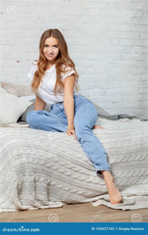 Indoor Portrait Of A Beautiful Blonde Woman Posing Sitting On A Bed Stock Image Image Of
