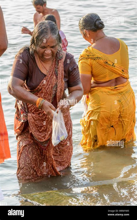 un hindú mujer vistiendo un sari realiza una mañana temprana del baño ritual en el río ganges en
