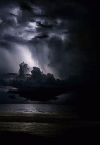 Storm Clouds Over The Ocean With Lightning In The Sky Above It And Dark