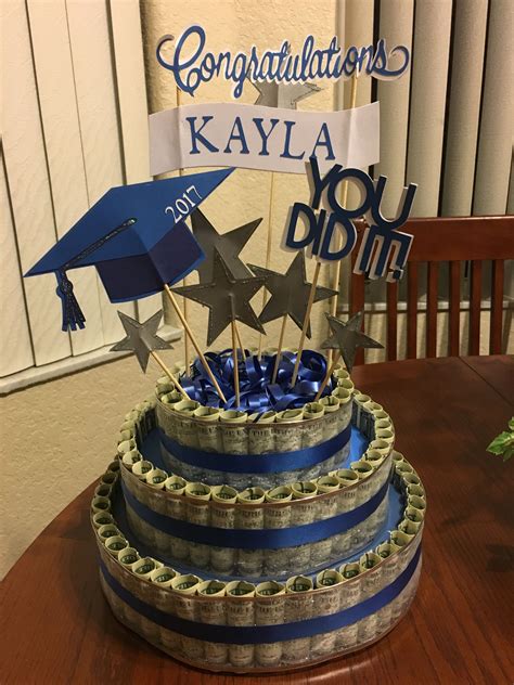 A Graduation Cake Is Decorated With Money And Blue Ribbon For The