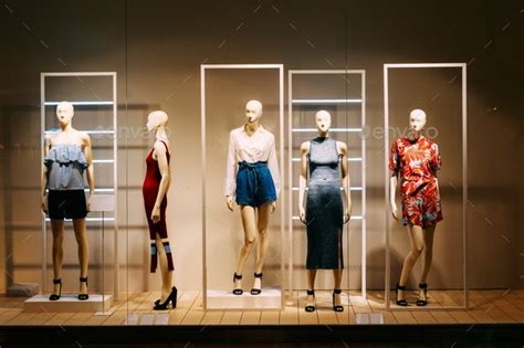 Five Mannequins Standing In Store Window Display Of Womens Casu