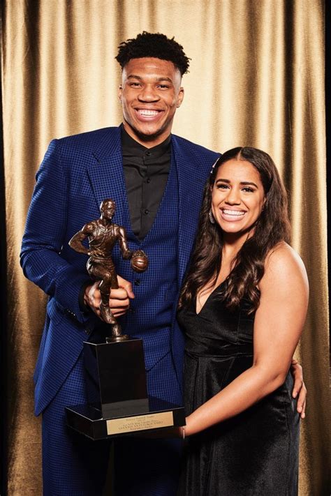 A Man And Woman Posing With An Award