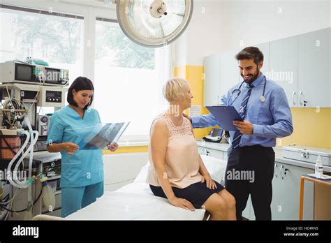 Male Doctor Interacting With A Patient While Nurse Looking At X Ray