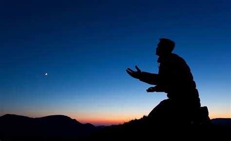 Man Pleading On The Summit Of A Mountain At Sun Set With The Moon In