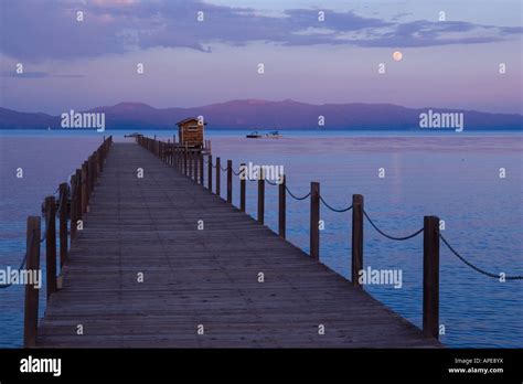 The Full Moon Rising Over Lake Tahoe California And A Pier Stock Photo