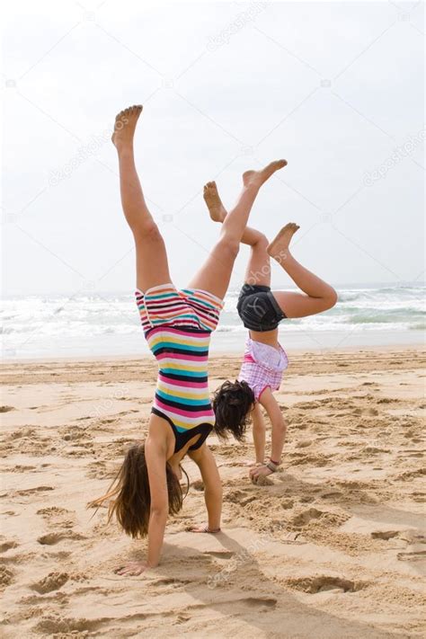 Two Teen Girls Doing Handstand On Beach — Stock Photo © Michaeljung