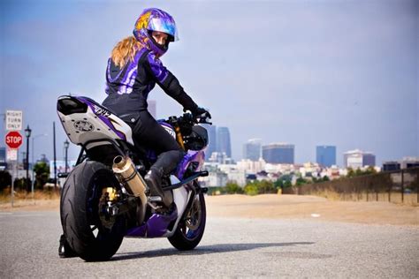 A Woman Riding On The Back Of A Purple Motorcycle