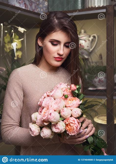 Young Beautiful Brunette Business Woman Florist Holding Trendy Bouquet Of Peony Roses In Flower