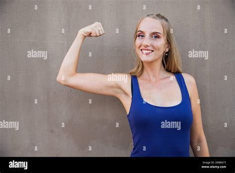 A Young Woman With Her Bicep Raised Strength Concept Model Isolated