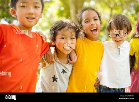 Multi Ethnic Group Of School Children Laughing And Embracing Stock