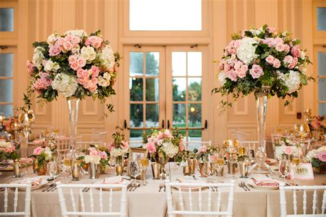 Two Tall Vases Filled With Pink And White Flowers Sit On Top Of A Table