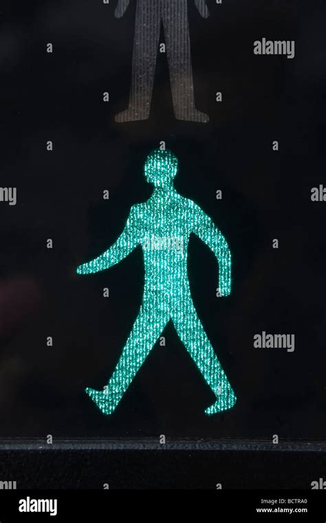 Close Up Of Illuminated Walking Green Man Safe To Cross Road Symbol On