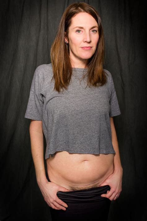 A Pregnant Woman Posing For A Photo In Front Of A Black Background With