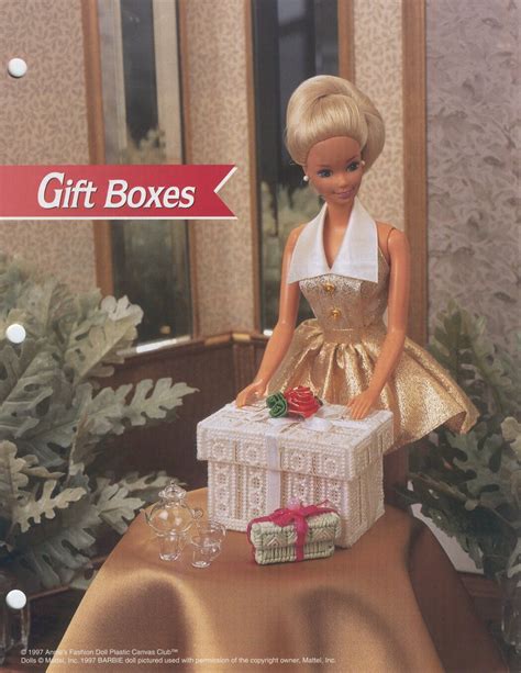 A Barbie Doll Sitting On Top Of A Table With A Gift Box In Front Of Her