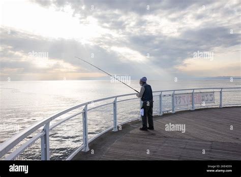 A man fishing at Enoshima Beach during sundown. Enoshima beach is a