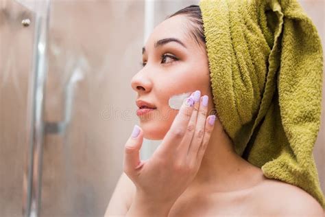 Gorgeous Girl Applying Moisturizing Cream On Her Face After A Shower Skin Care Stock Image