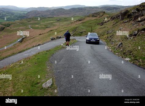 Two Men Passing a Car Walking Down the Hard Knott Pass Road to Eskdale
