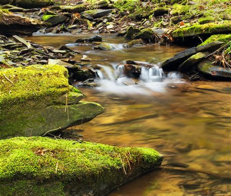 Time Lapse Photography Of Flower Water In Between Mossy Rock Formations