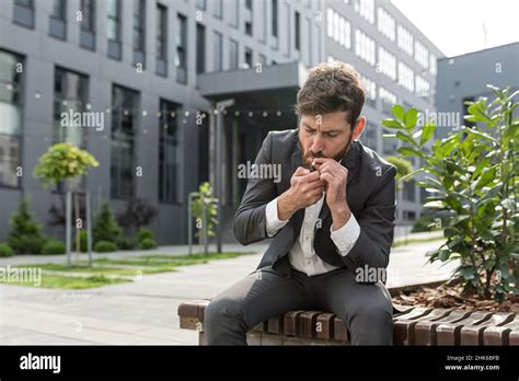 Male Businessman Smoking Cigarette In The Air Near The Office Relieves
