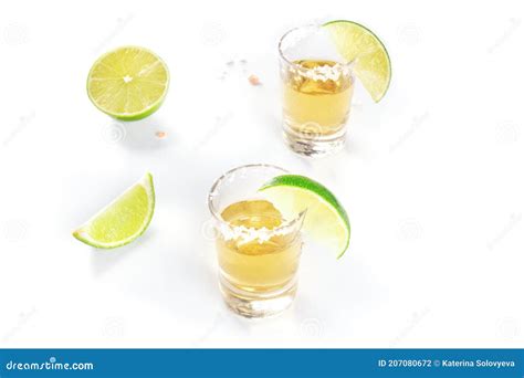 Golden Tequila Shots With Lime Slices And Salty Rims On White Stock