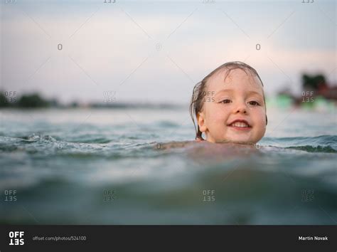 Profile Of Young Girl Swimming In Lake With Head Above Water Stock
