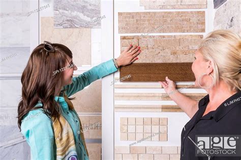 Design Consultant And Interior Designer Selecting Tiles In Showroom Of