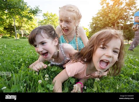 Little Smiling Girls Girlfriends On The Green Grass Crazy Kids Stock